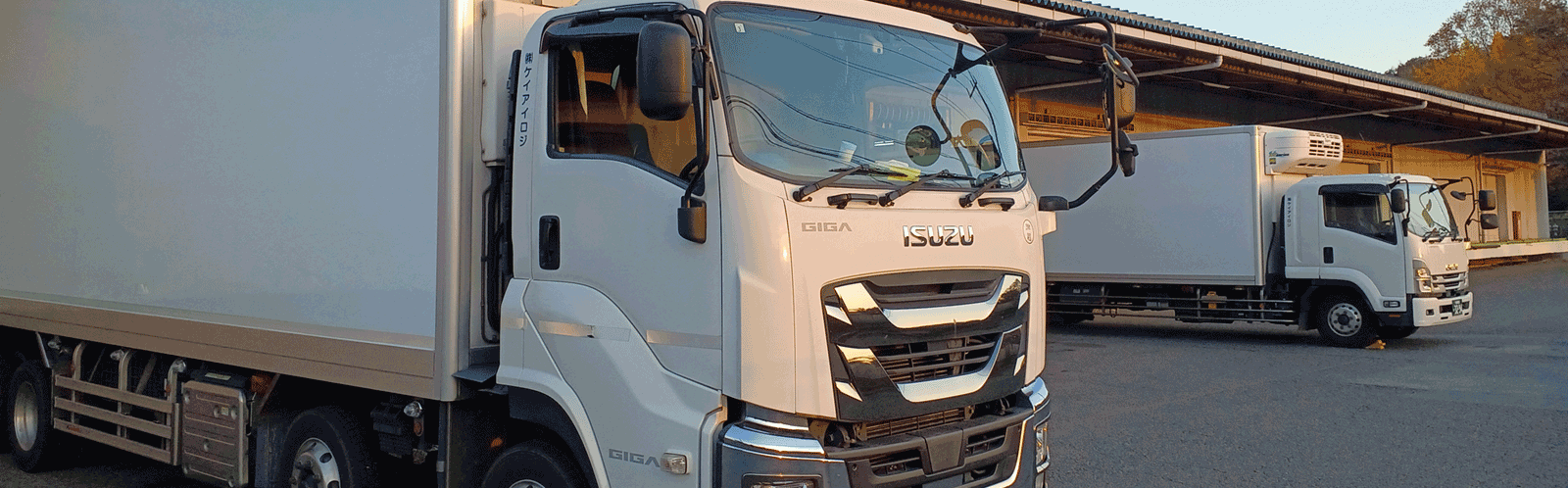 トラックが倉庫から出るヒーロー画像